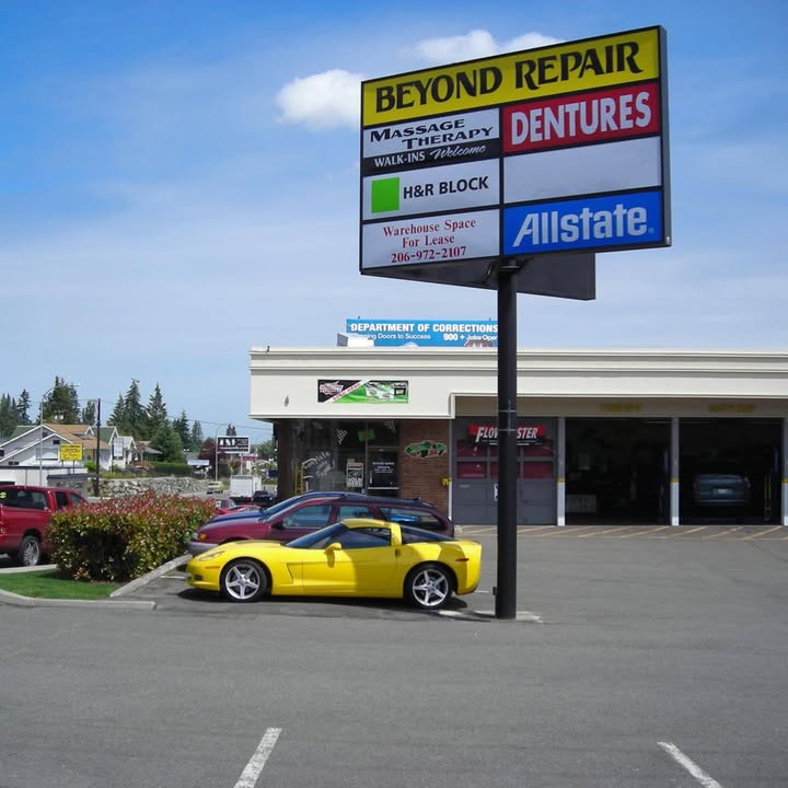 Our shop front on Rucker Avenue: the pylon sign with the yellow BEYOND REPAIR panel, three bay doors, and a Flowmaster banner over the left bay.